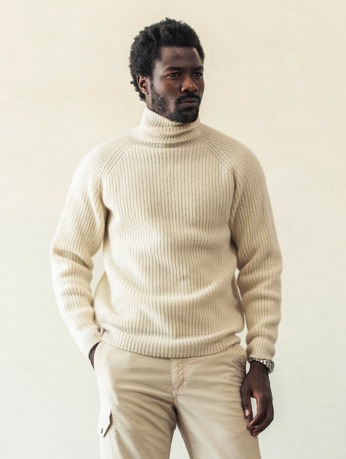 Front view of man with hand in pant pocket wearing Finley Sweater in Winter White from AETHER Apparel.