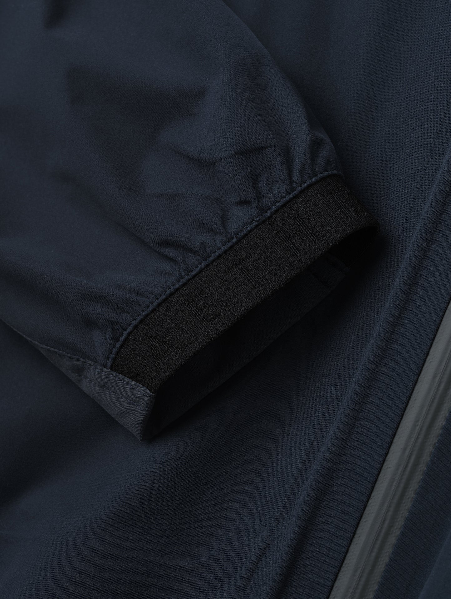 Closeup detailed view of one of the elasticated sleeve cuffs on the Frontier Pant in Total Eclipse dark blue from AETHER Apparel.
