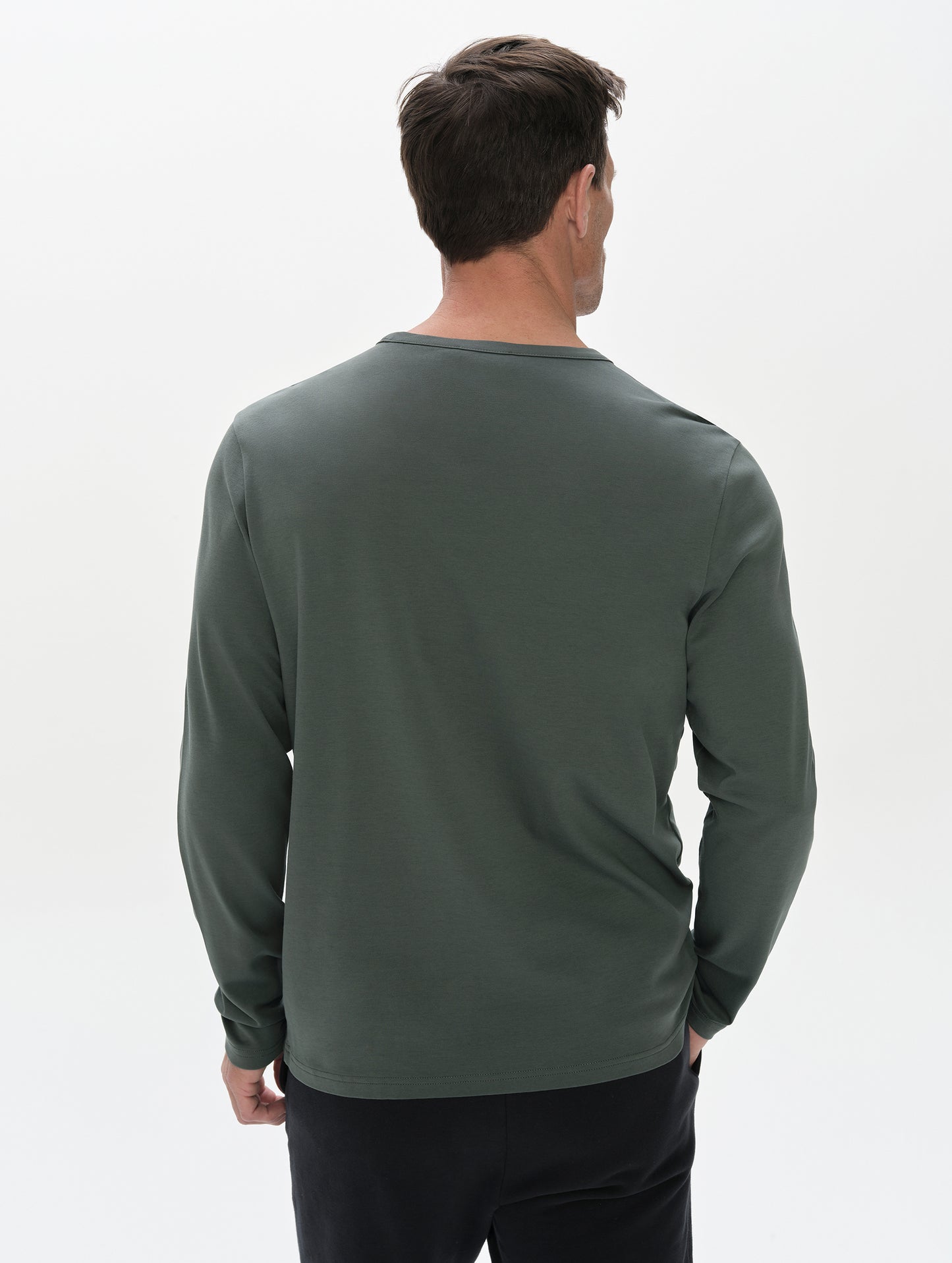 Rear, upper-body view of man wearing Harlow Premium Long-Sleeve Tee in Saville Green from AETHER Apparel.