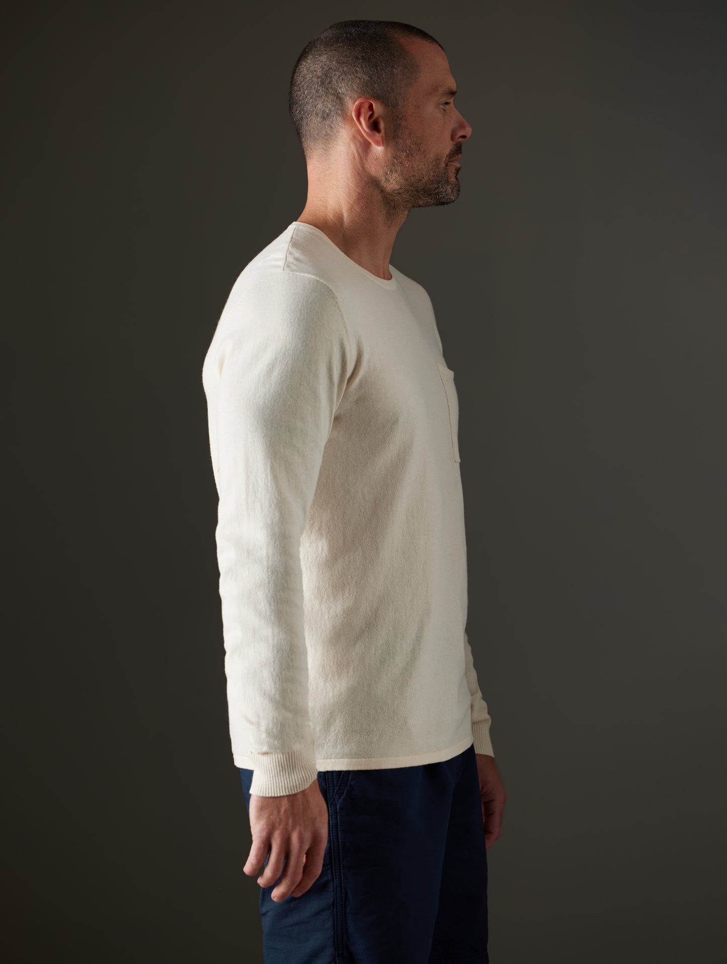 Side profile body view of man wearing Aero Sweater in Oatmeal Heather from AETHER Apparel.