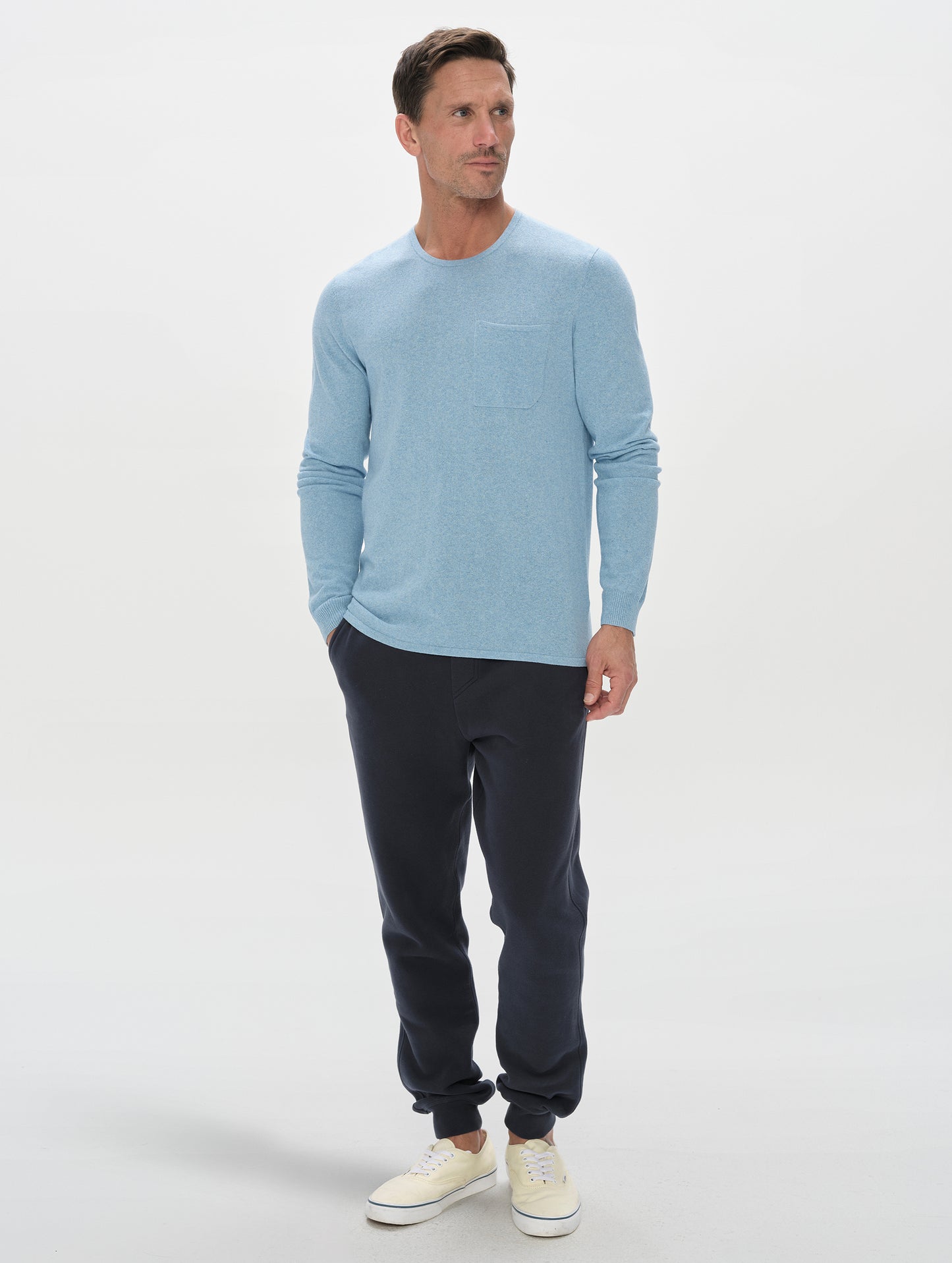 Front, full-body view of the man wearing the Aero Crewneck Sweater 2.0 in Cloud Blue from AETHER Apparel.