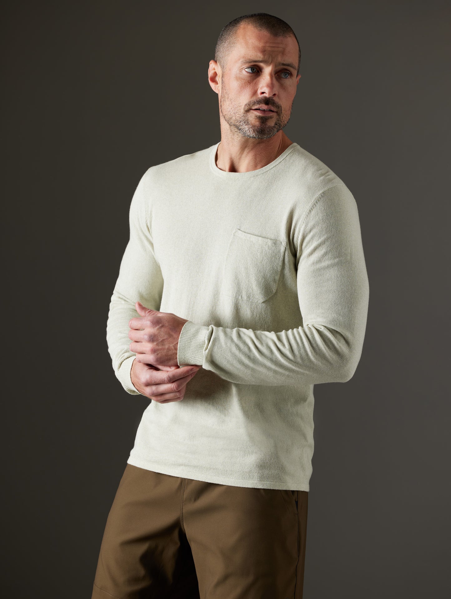 Front 3/4 body view of man wearing Aero Sweater in Light Sage Heather from AETHER Apparel.