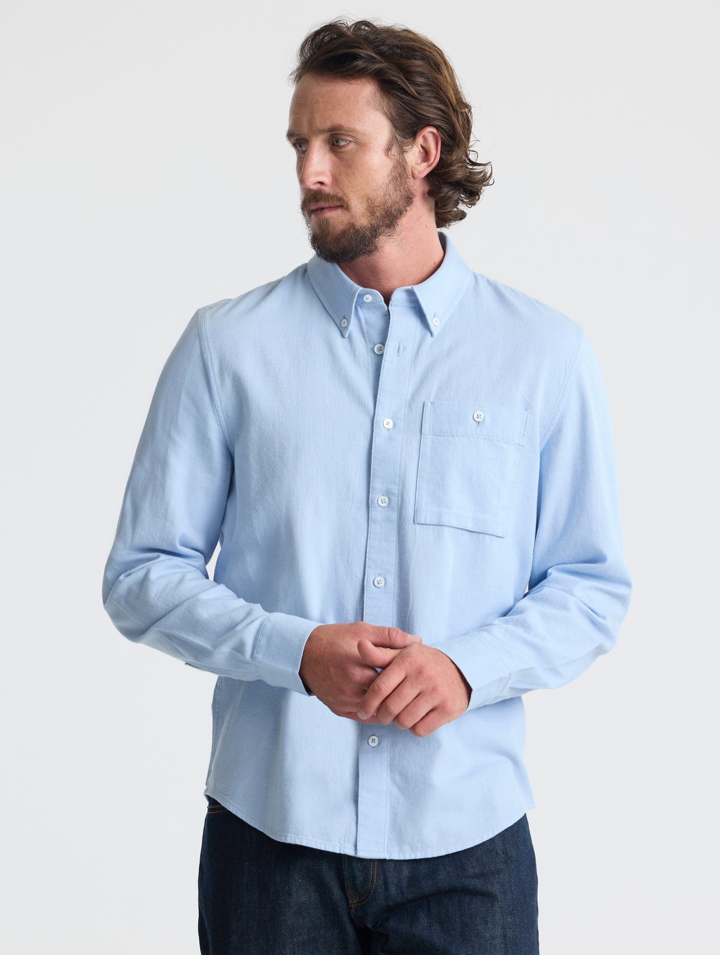 Front view of man wearing Alder Chambray Button-Down in Light Blue from AETHER Apparel.