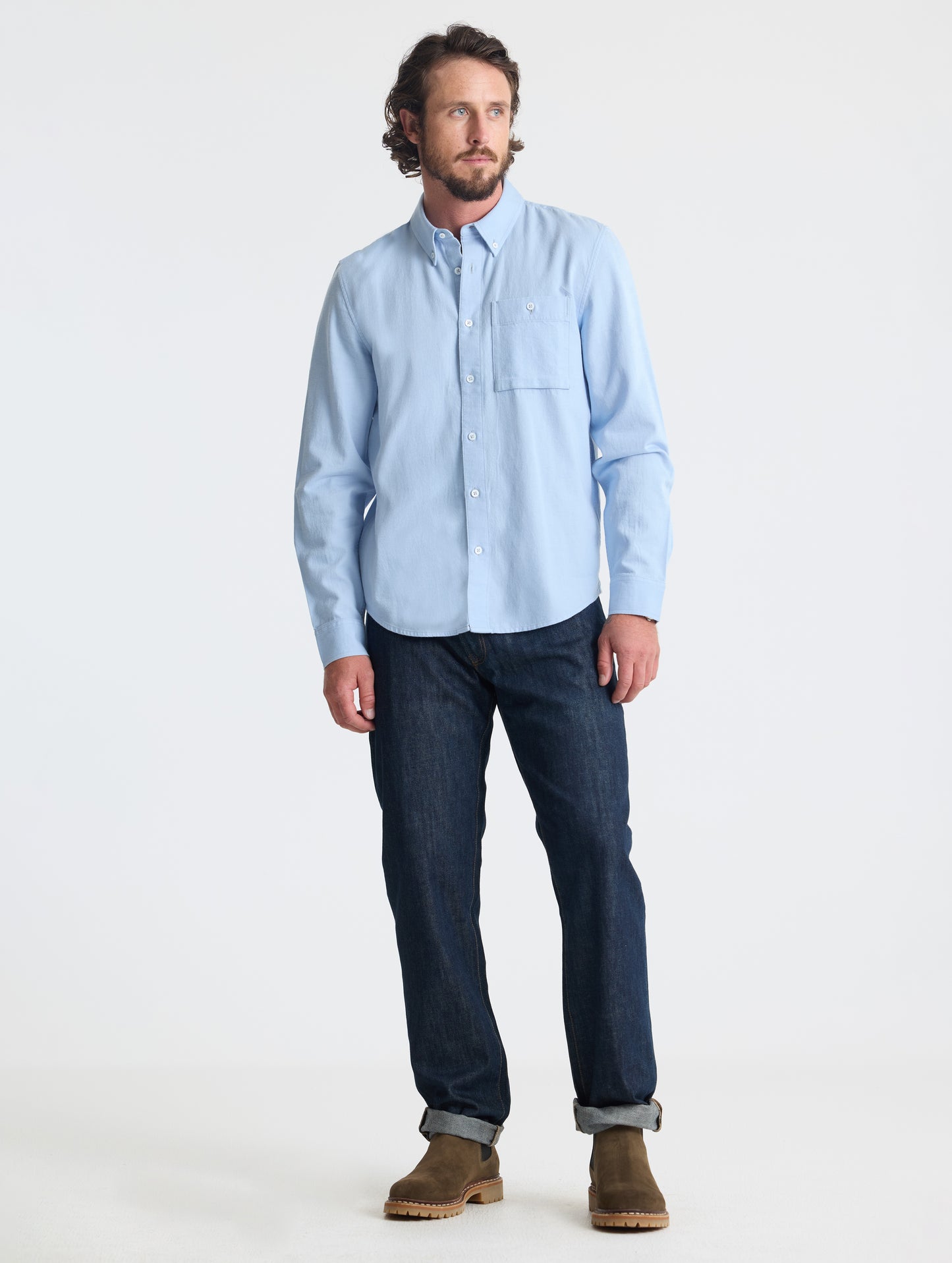 Full body view of man wearing Alder Chambray Button-Down in Light Blue from AETHER Apparel.
