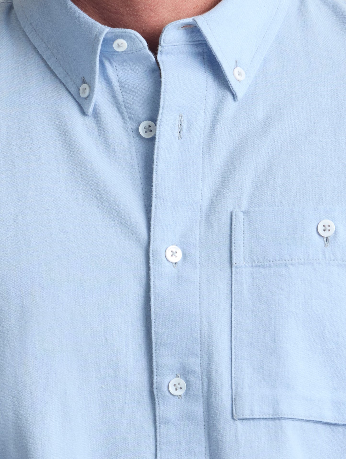 Closeup view of center buttons and chest pocket of Alder Chambray Button-Down in Light Blue from AETHER Apparel.
