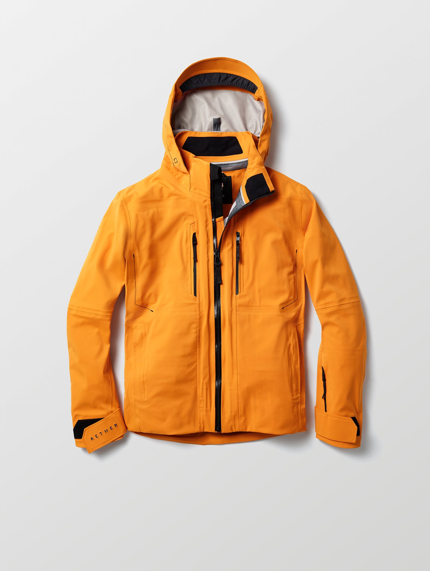 Flat lay of Altitude Snow Shell 2.0 in Autumn Orange from AETHER Apparel.