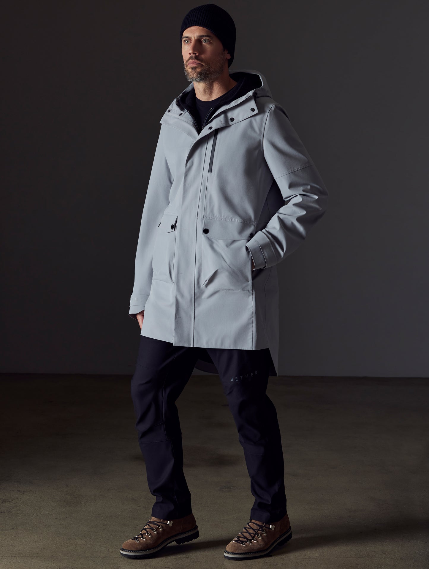 Front 3/4 full-body view of man wearing Anders Rain Jacket in Sky Grey from AETHER Apparel.