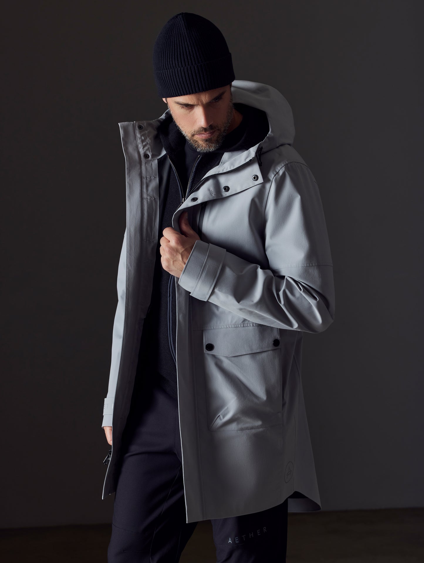 Front 3/4 body view of man wearing Anders Rain Jacket in Sky Grey from AETHER Apparel.