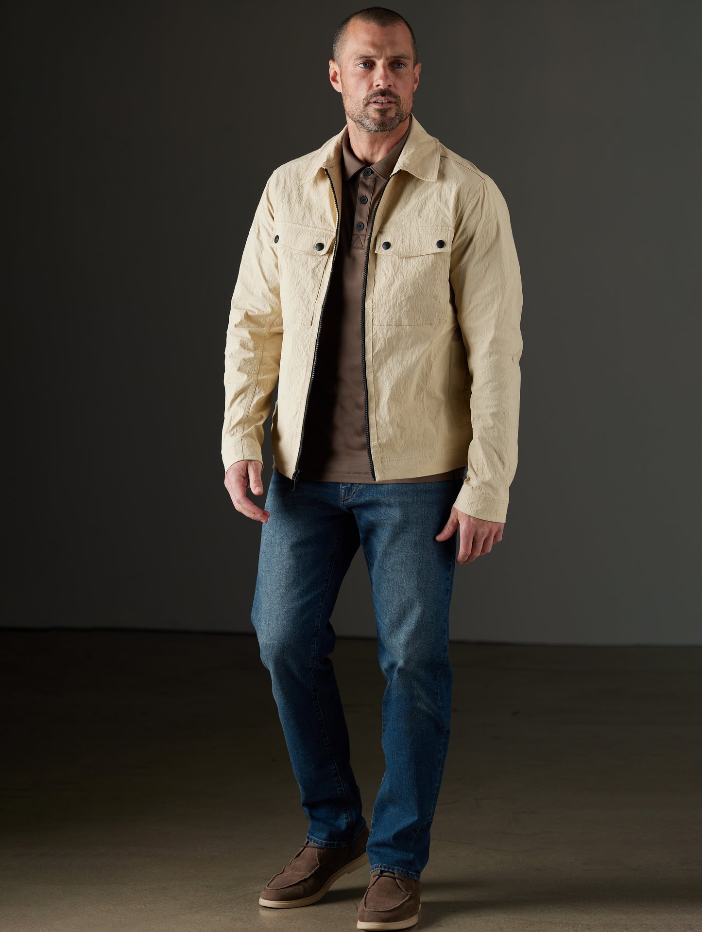 Front full-body view of man wearing Baxter Jacket in Desert Tan from AETHER Apparel.