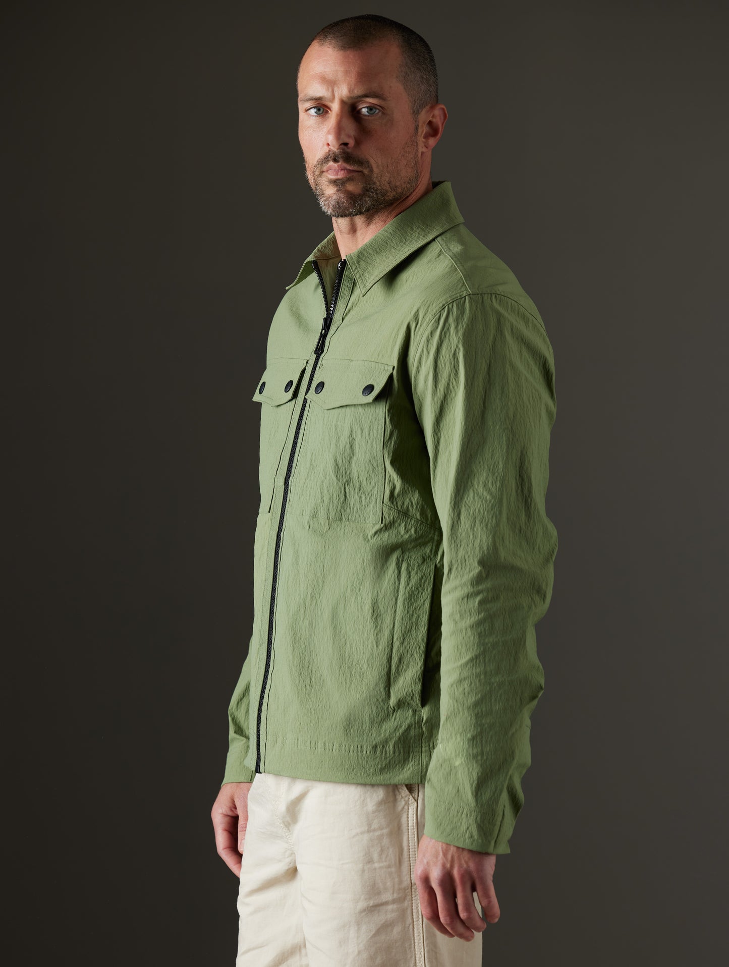 Front 3/4 body view of man wearing Baxter Jacket in Mineral Green from AETHER Apparel.