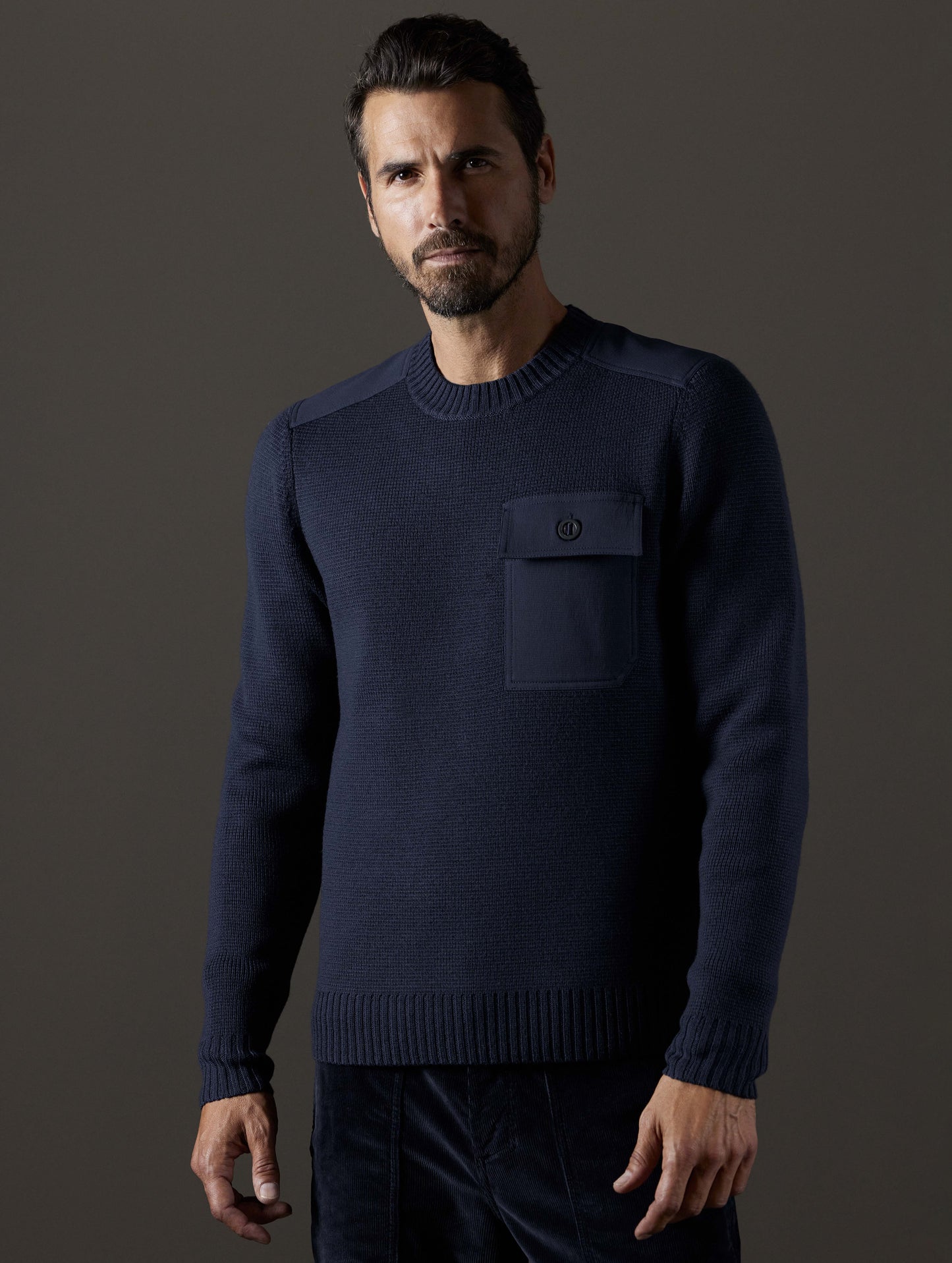 Front 3/4 body view of man wearing Benson Crewneck Sweater in Total Eclipse dark blue from AETHER Apparel.