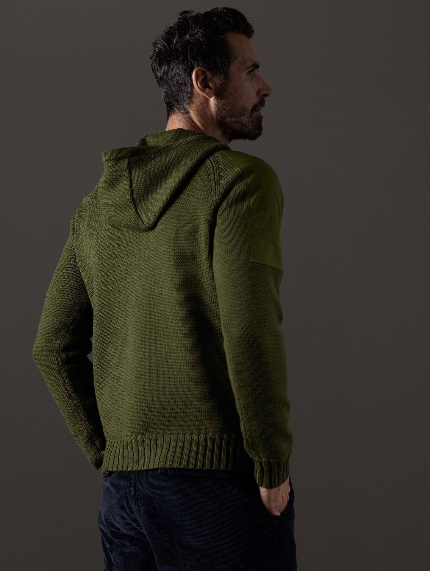 Rear 3/4 body view of man wearing Benson Hooded Sweater in Command Green from AETHER Apparel.