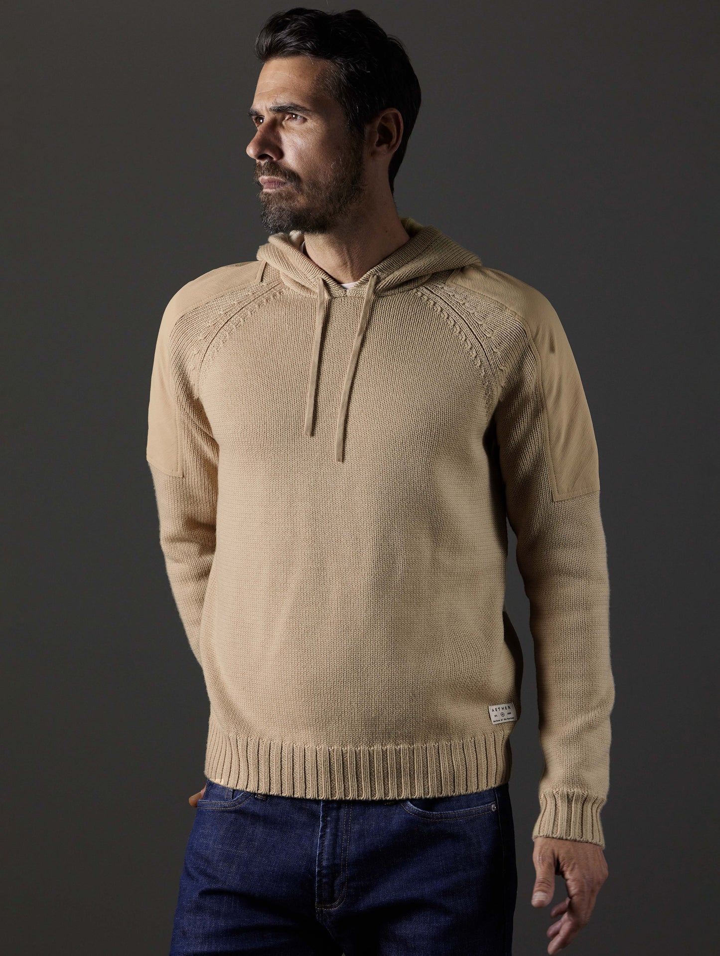 Front body view of man wearing Benson Hooded Sweater in Oatmeal beige from AETHER Apparel.