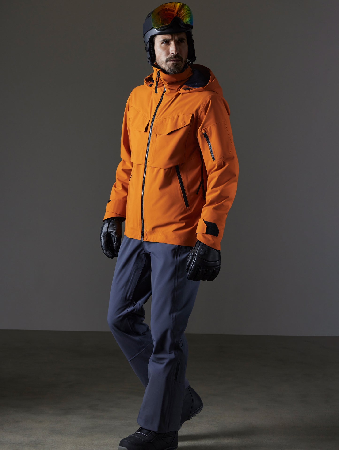 Front 3/4 full-body view of man wearing Brighton Insulated Snow Jacket in Autumn Orange from AETHER Apparel.