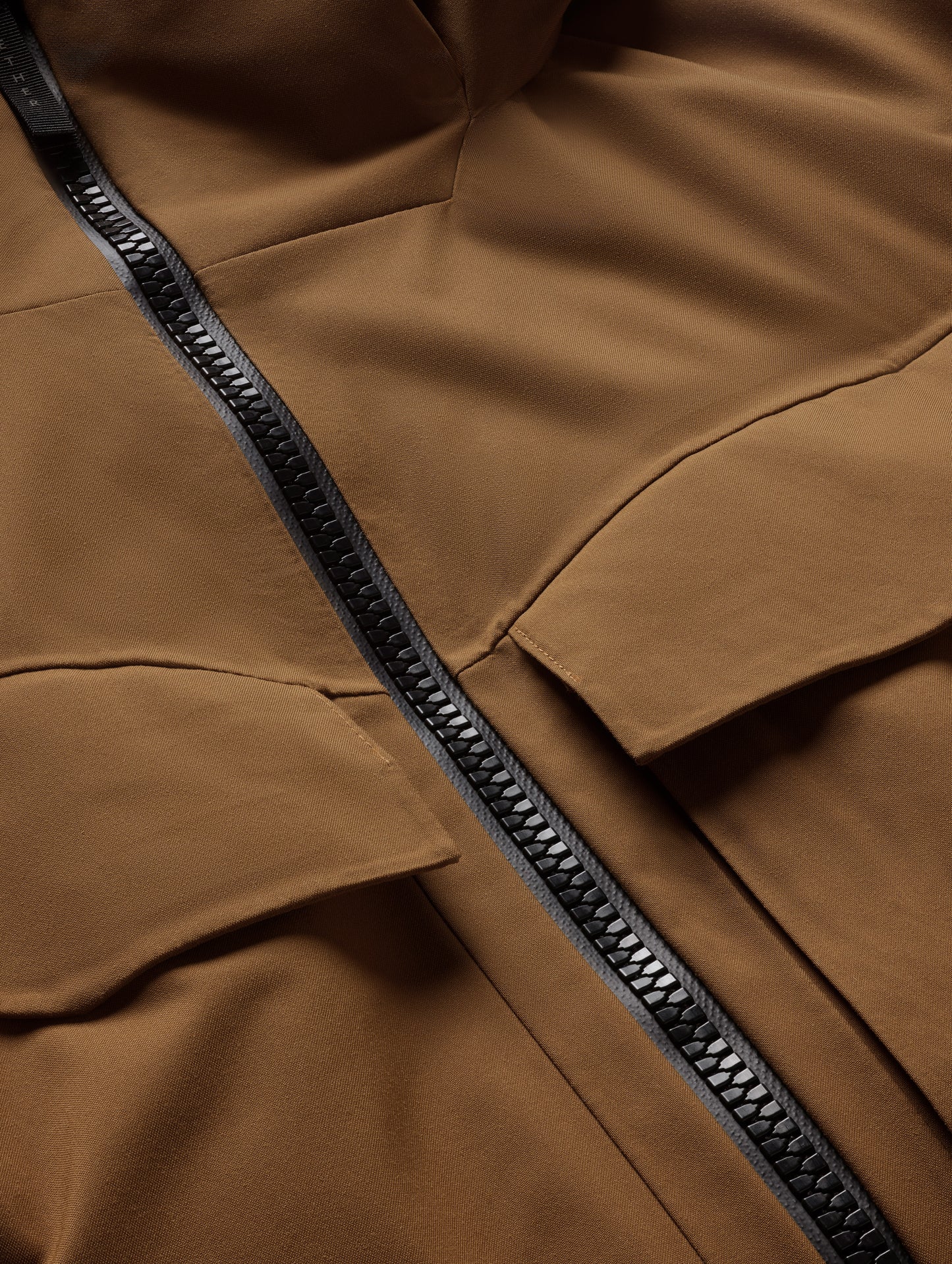 Closeup detailed view of the main center-front zipper on the Brighton Insulated Snow Jacket in Rubber Brown from AETHER Apparel.