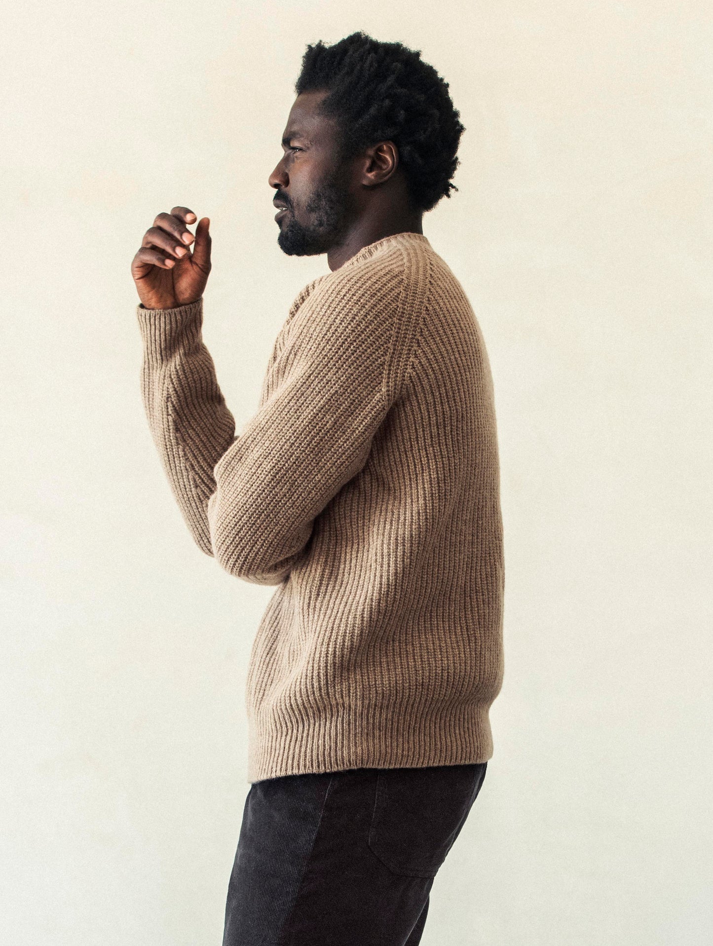 Side profile body view of man wearing Camden Crewneck Sweater In Chestnut Brown from AETHER Apparel