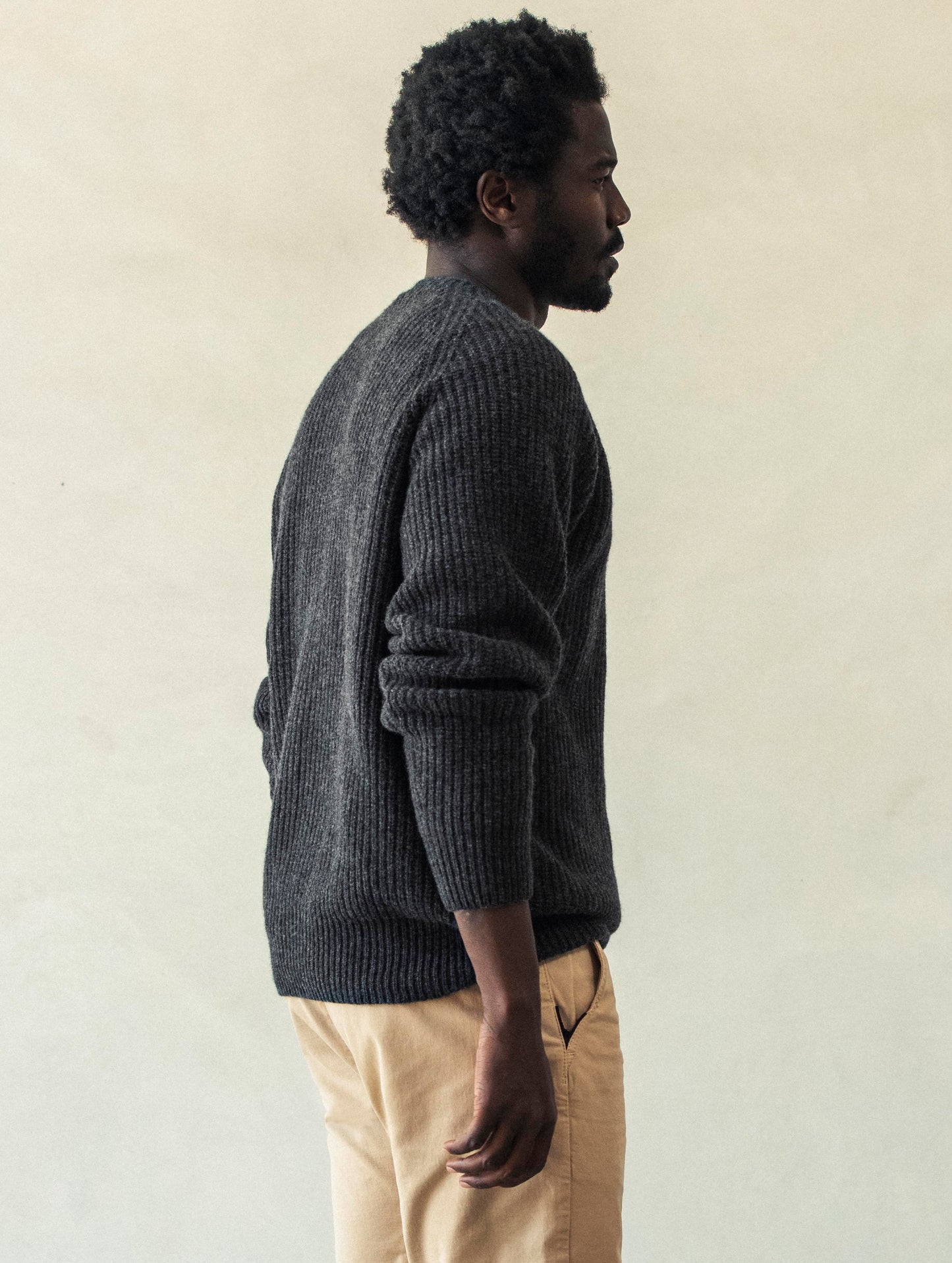 Rear 3/4 body view of man wearing Camden Crewneck Sweater In Charcoal Heather from AETHER Apparel.