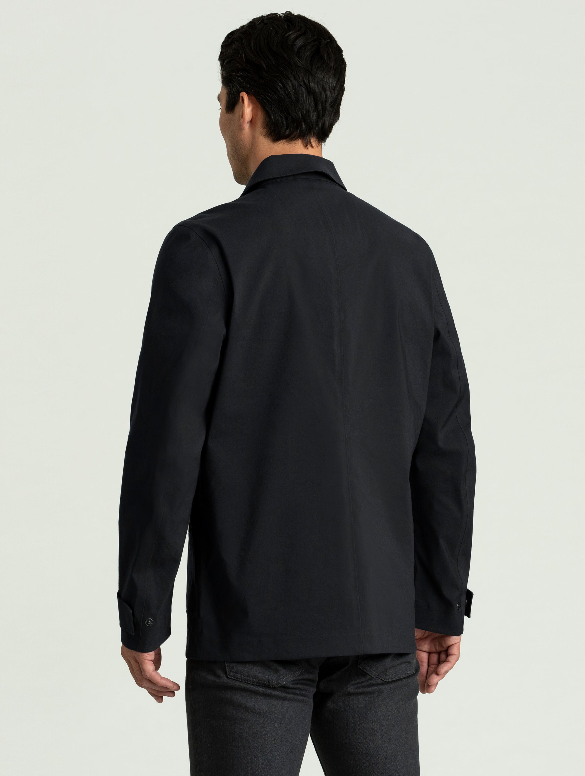 Back view of man wearing black Cole Jacket from AETHER Apparel.