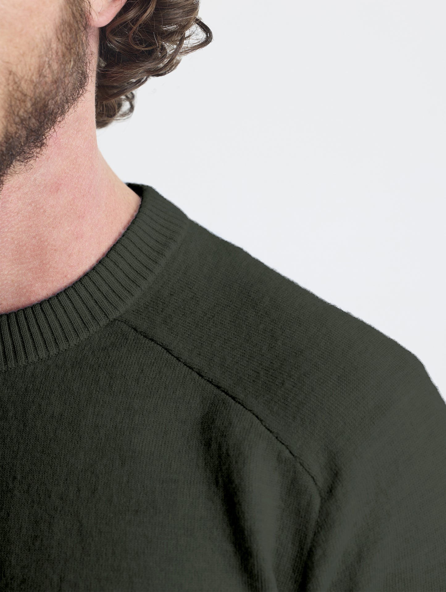 Closeup detail view of wearer's left shoulder stitch of Corbin Sweater in Forest Green from AETHER Apparel.