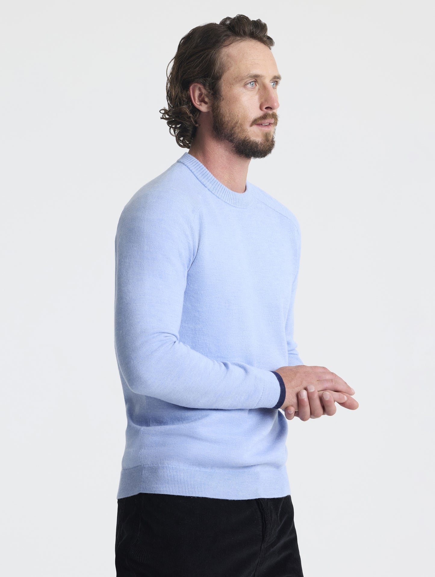 Angled front view of man with hands crossed wearing Corbin Sweater in Light Blue Heather from AETHER Apparel.