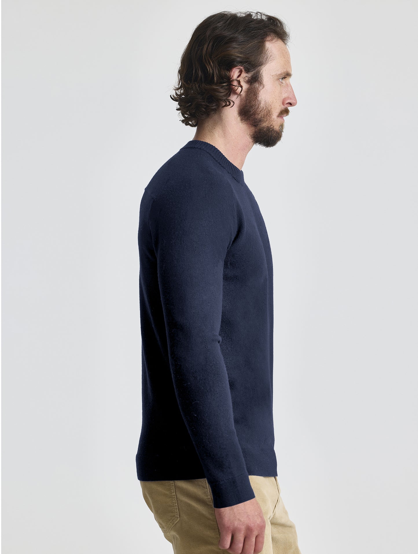 Right profile view of man wearing Corbin Sweater in Total Eclipse dark blue from AETHER Apparel.