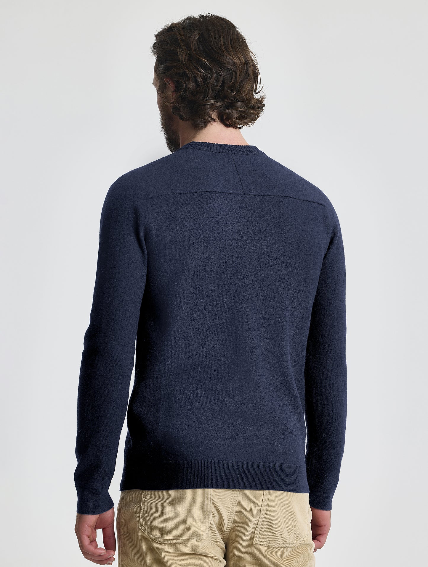Rear view of man wearing Corbin Sweater in Total Eclipse dark blue from AETHER Apparel.