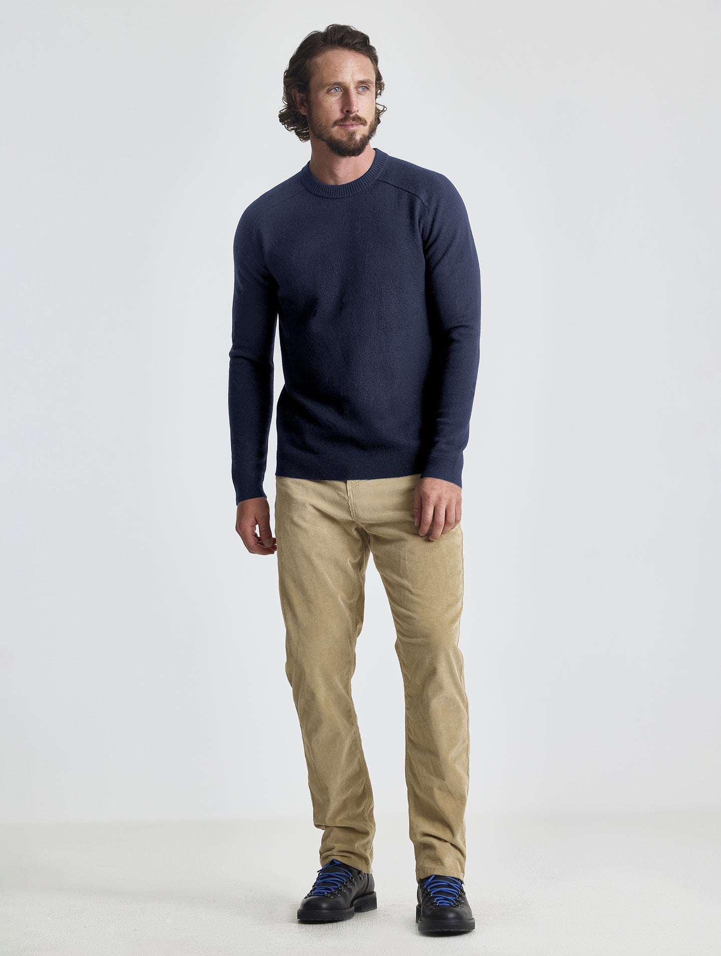 Full body view of man wearing Corbin Sweater in Total Eclipse dark blue from AETHER Apparel.