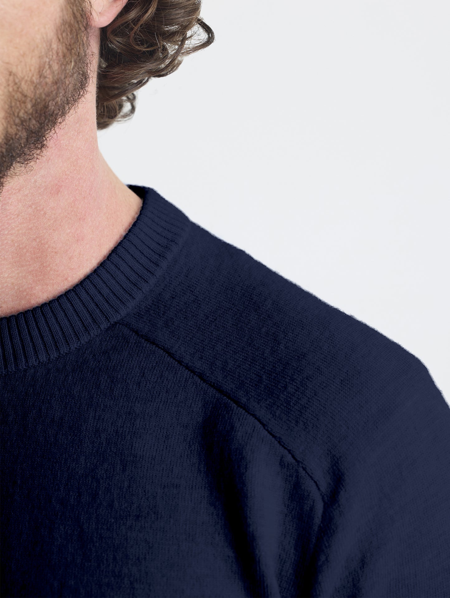 Closeup detail view of wearer's left shoulder of Corbin Sweater in Total Eclipse dark blue from AETHER Apparel.