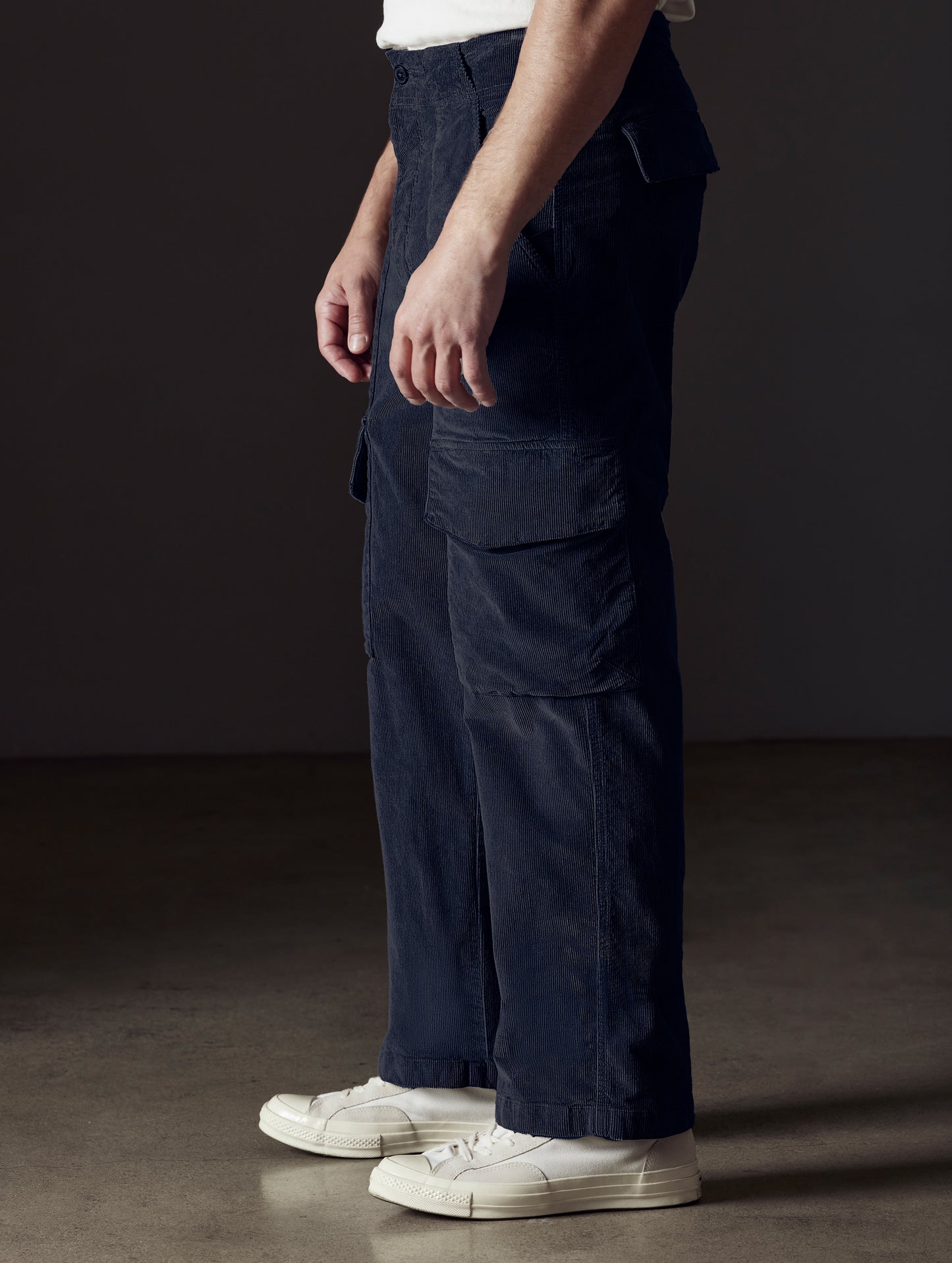 Side profile lower body view of man wearing Corduroy Fatigue Pant in Total Eclipse dark blue from AETHER Apparel.