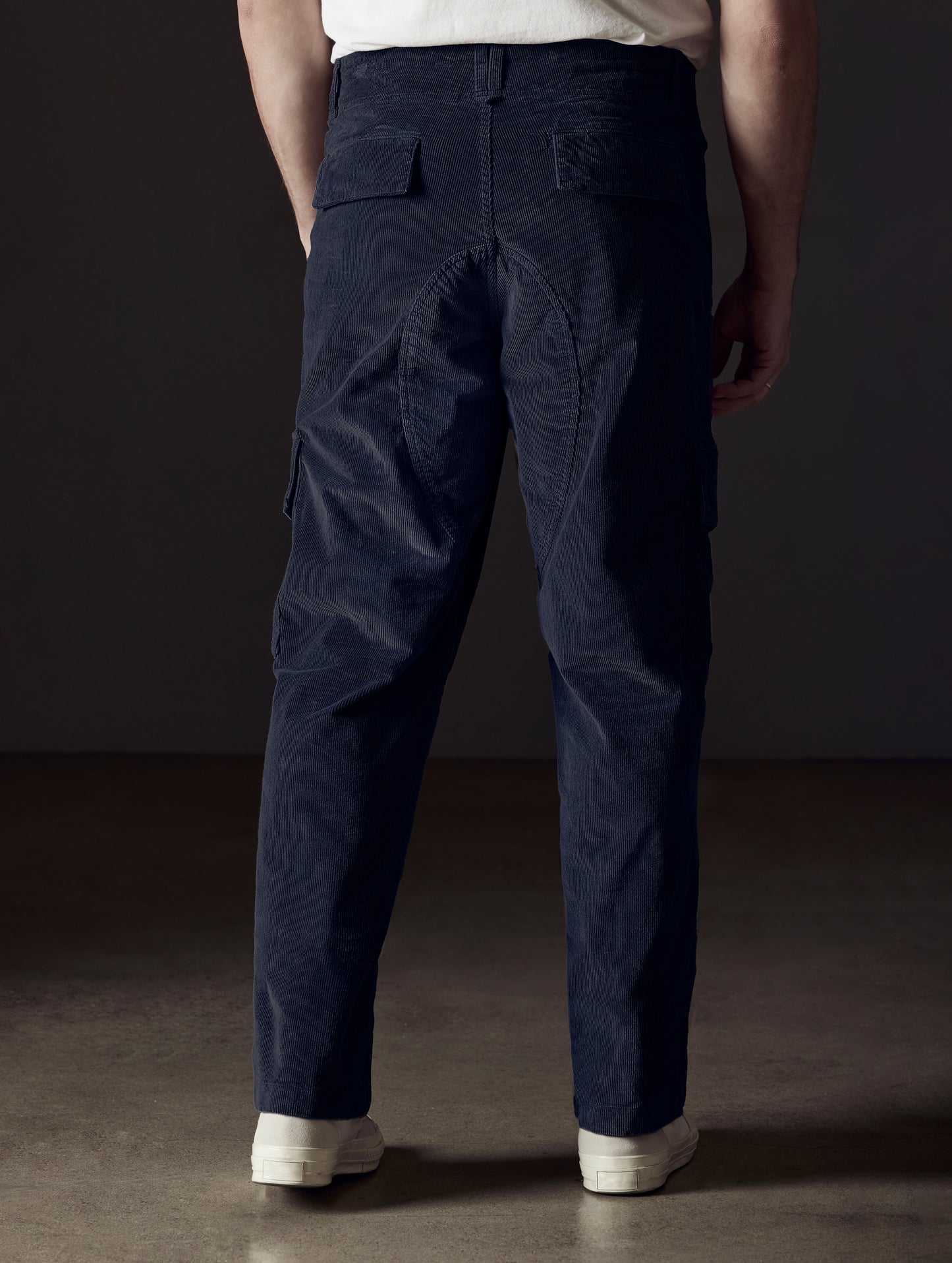 Rear lower body view of man wearing Corduroy Fatigue Pant in Total Eclipse dark blue from AETHER Apparel.