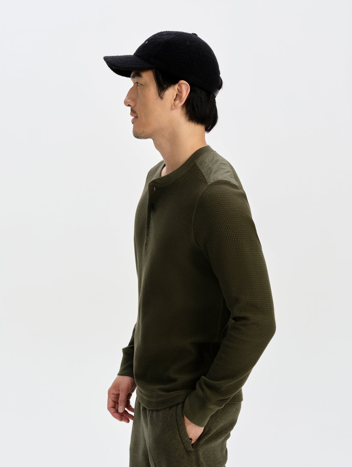 Side profile upper-body view of man wearing the Daley Waffle Henley in Forest Green from AETHER Apparel.