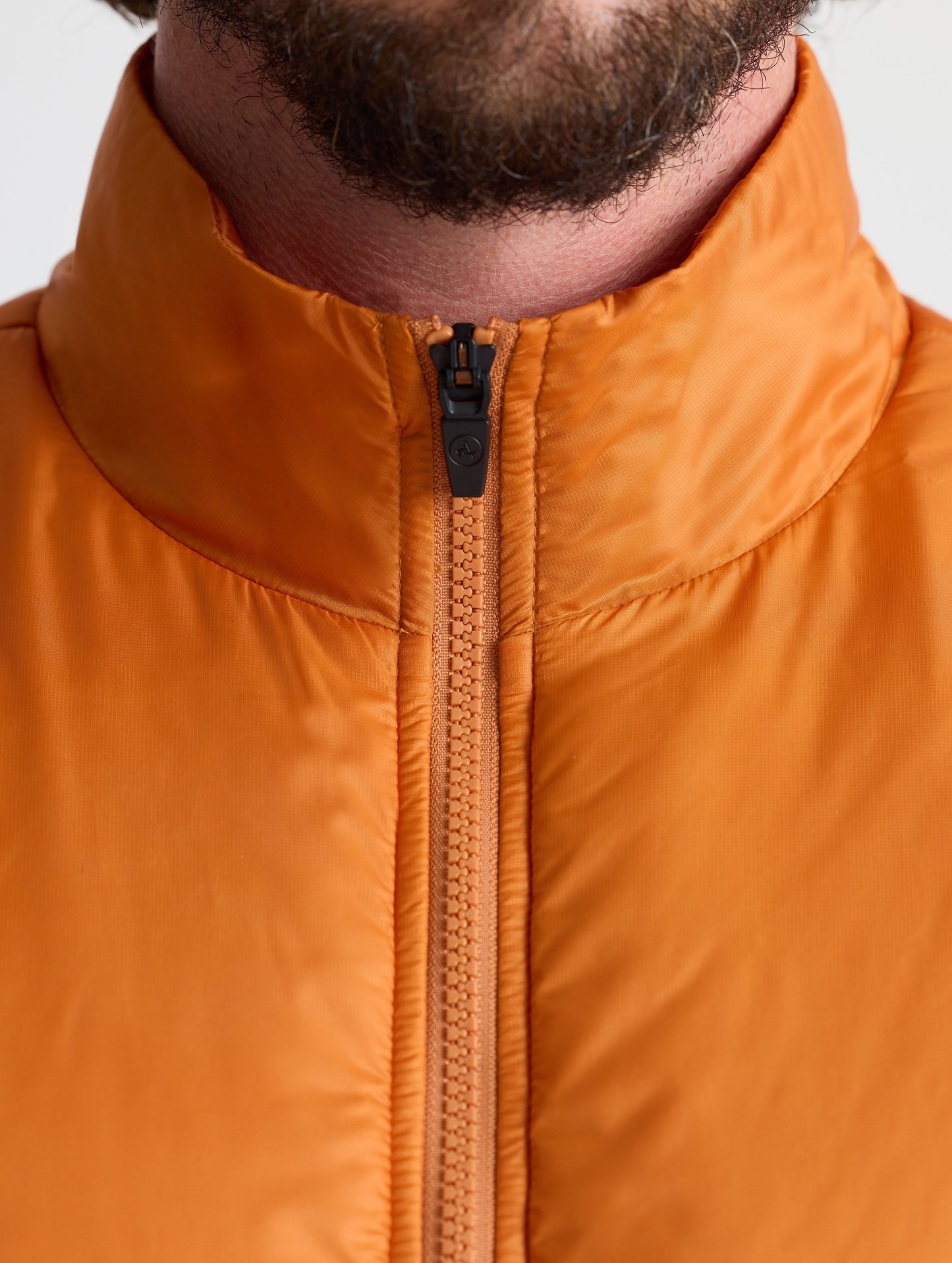 Closeup view of collar of Eco Insulated Jacket in Autumn Orange from AETHER Apparel.