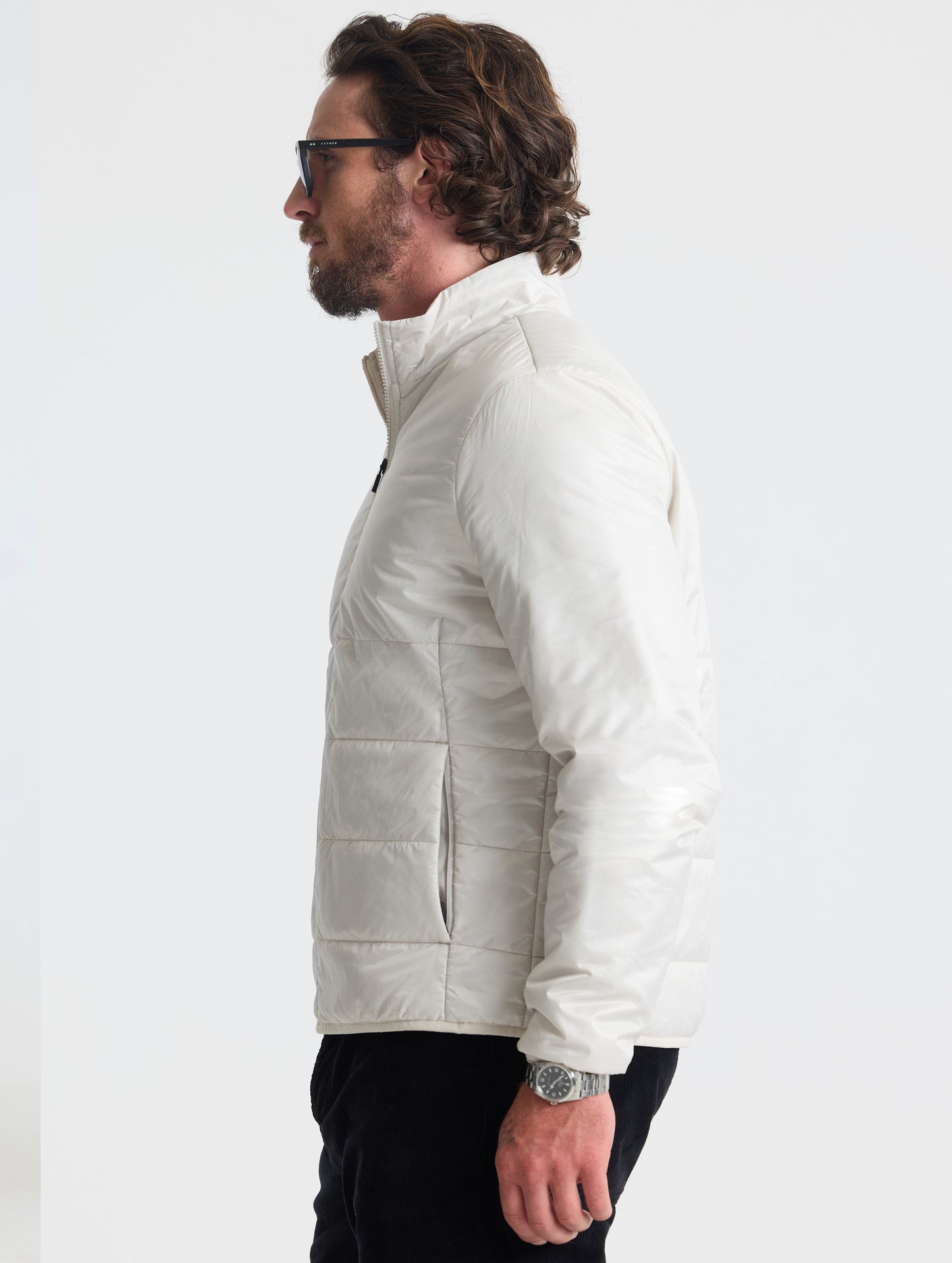 Left profile view of man wearing Eco Insulated Jacket in Bone white from AETHER Apparel.