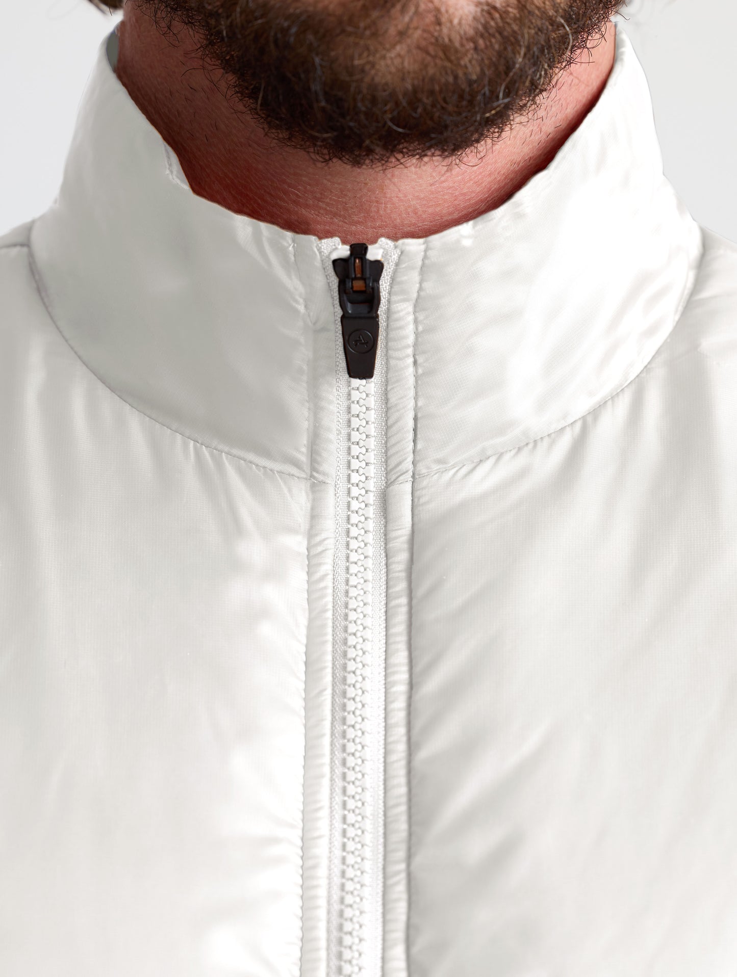 Closeup view of collar of man wearing Eco Insulated Jacket in Bone white from AETHER Apparel.