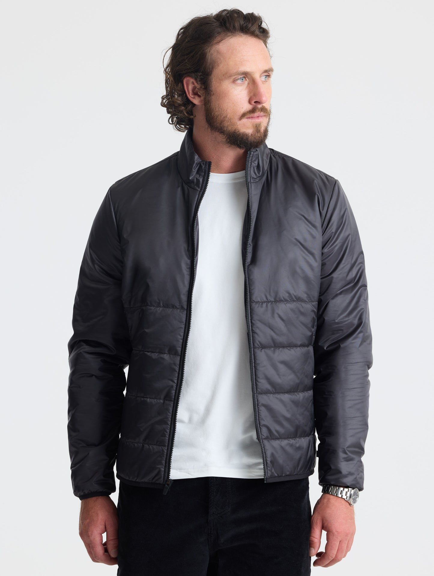 Front view of man wearing unzipped Eco Insulated Jacket in Onyx Black from AETHER Apparel.