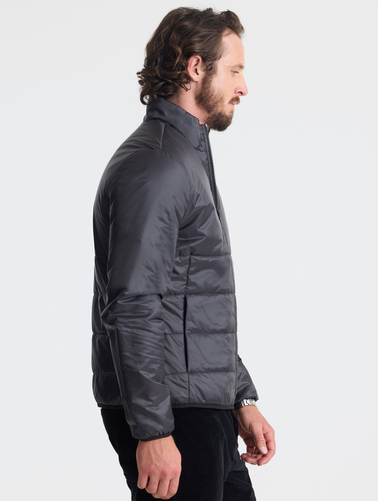 Right profile view of man wearing Eco Insulated Jacket in Onyx Black from AETHER Apparel.