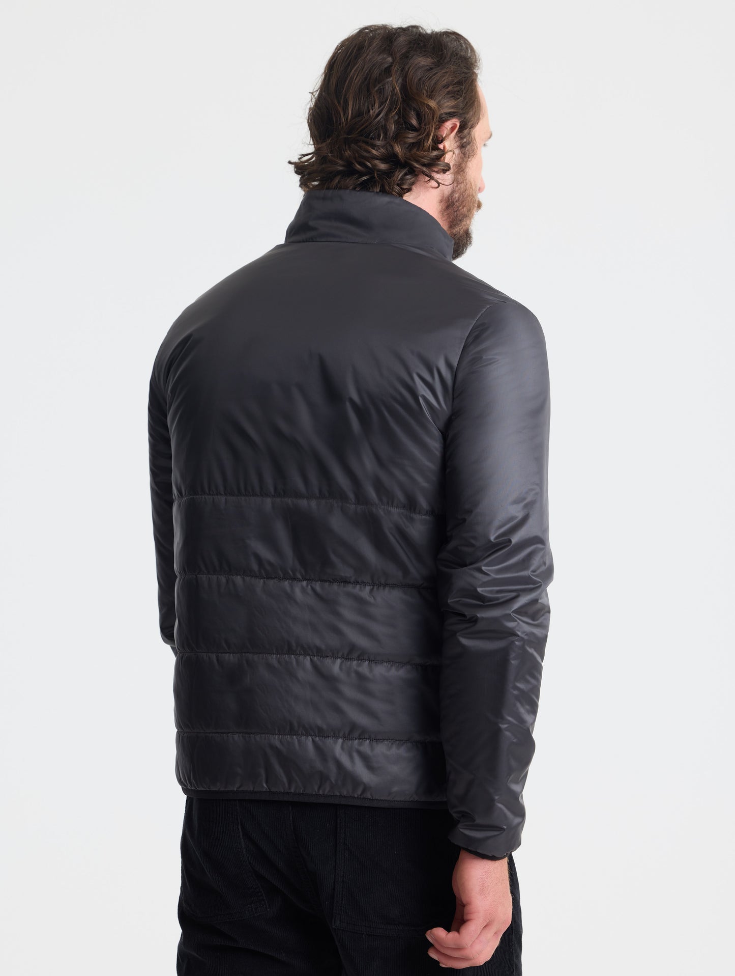 Rear view of man wearing Eco Insulated Jacket in Onyx Black from AETHER Apparel.