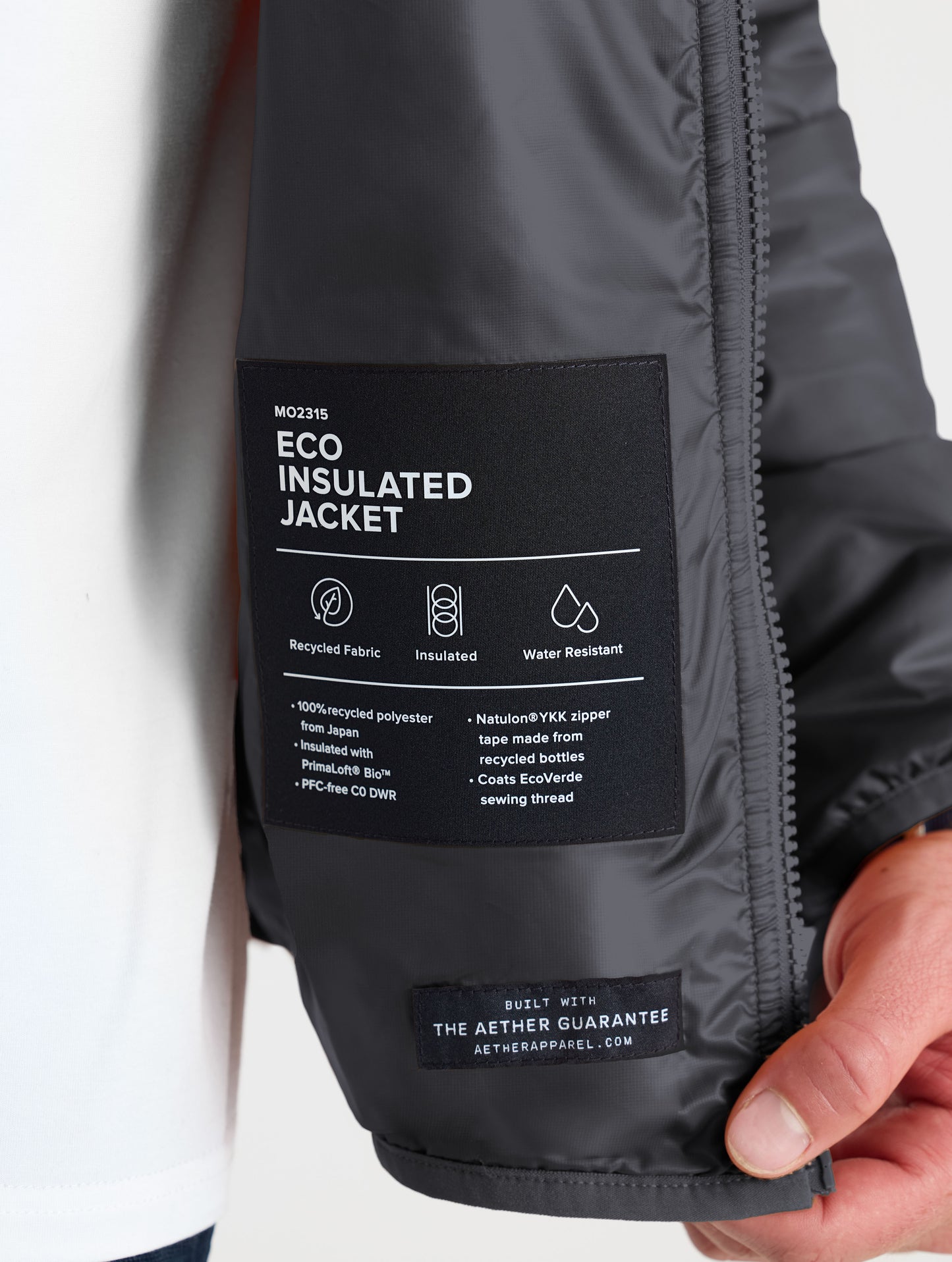Closeup view of wearer's left interior label of Eco Insulated Jacket in Onyx Black from AETHER Apparel.