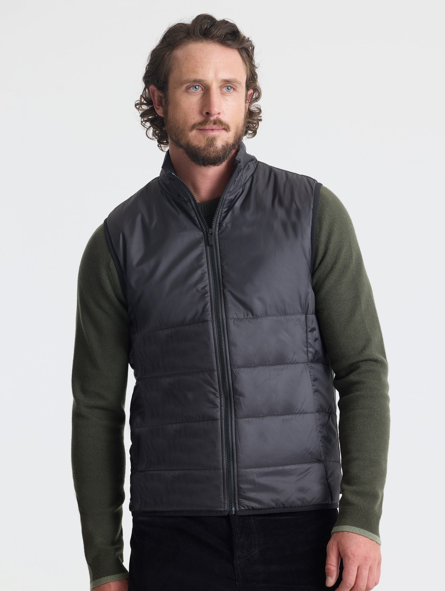 Front view of man wearing Eco Insulated Vest in Onyx Black from AETHER Apparel.