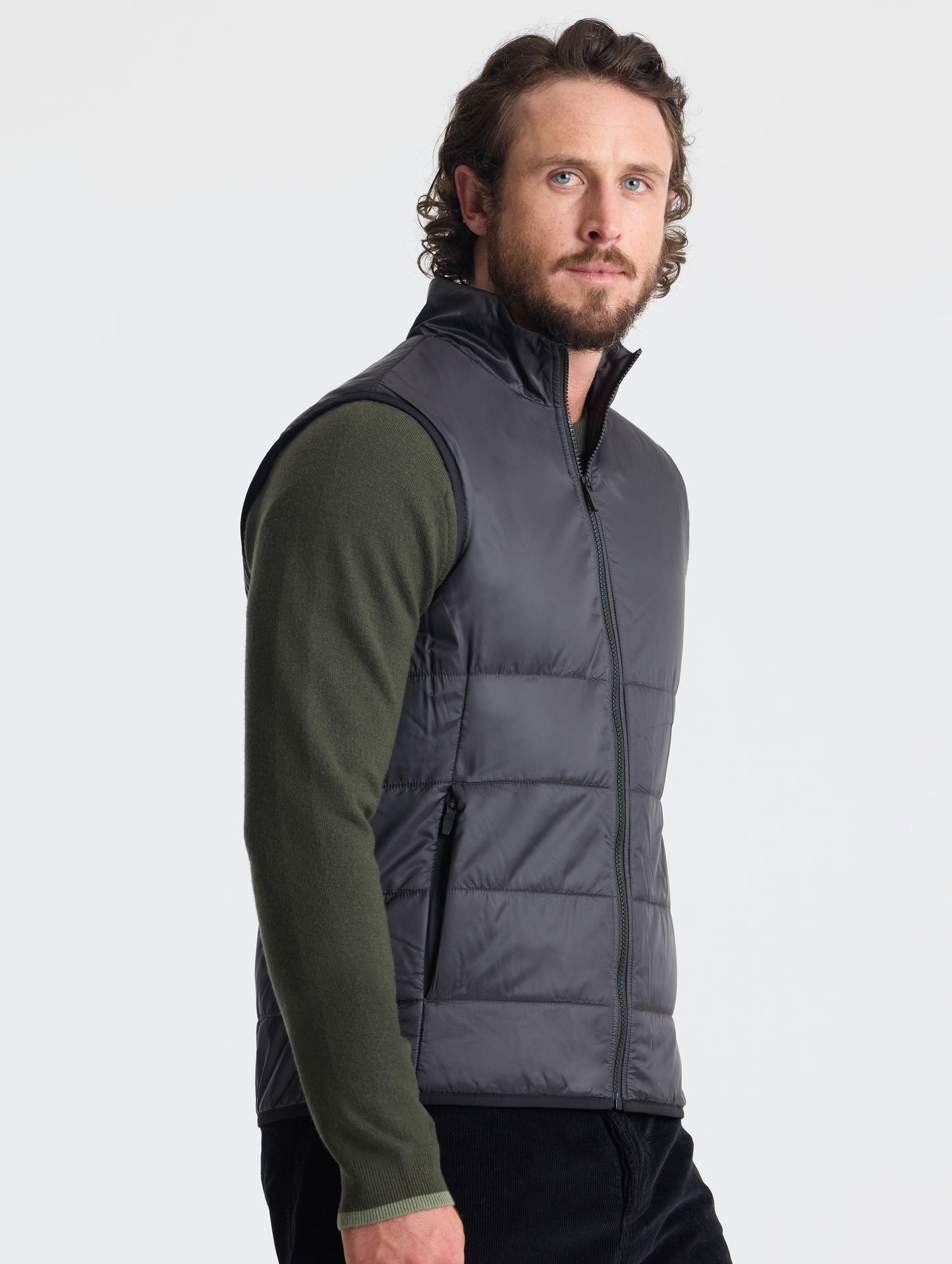 Right profile of man wearing Eco Insulated Vest in Onyx Black from AETHER Apparel.