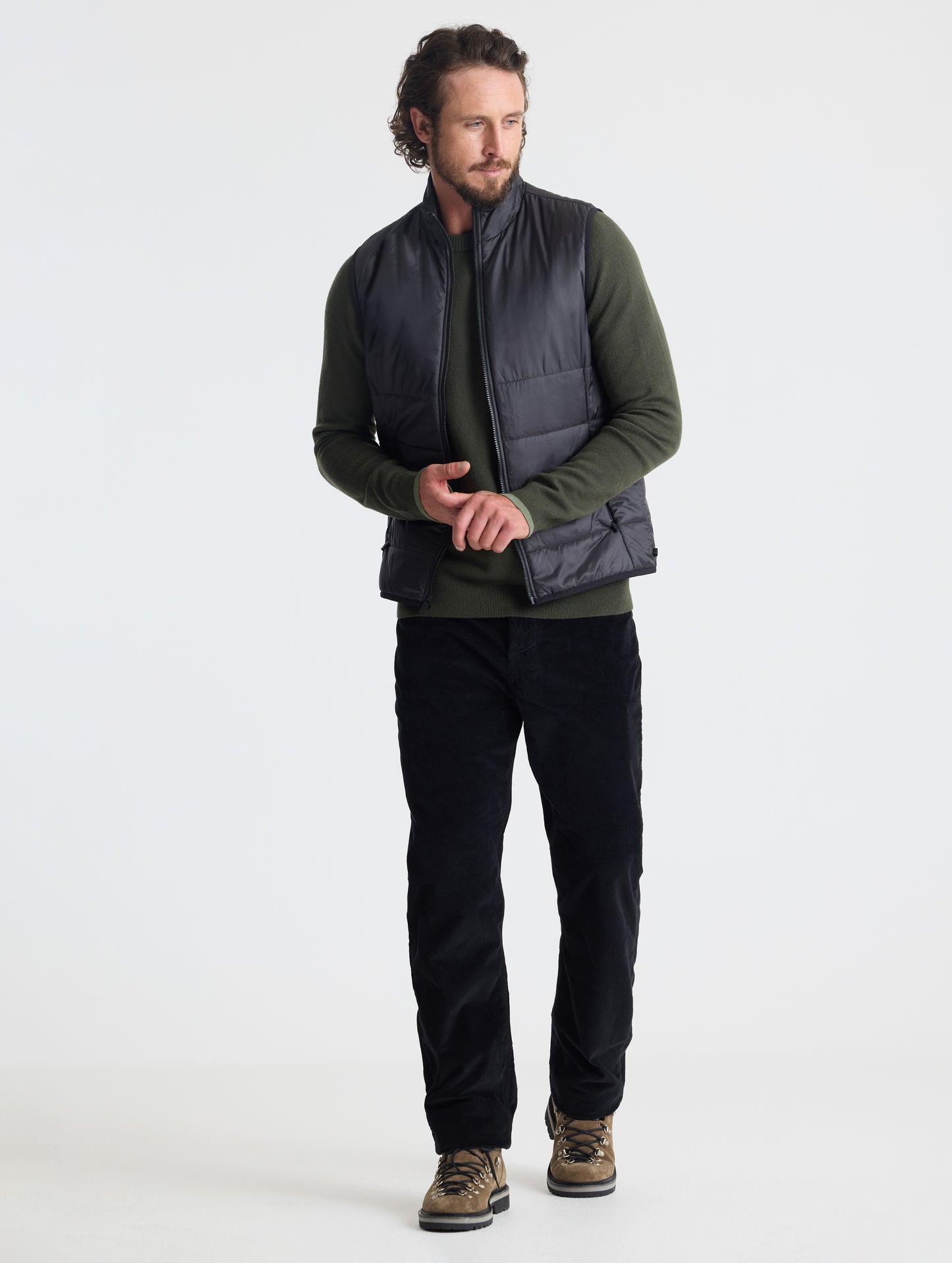 Full body view of man wearing Eco Insulated Vest in Onyx Black from AETHER Apparel.
