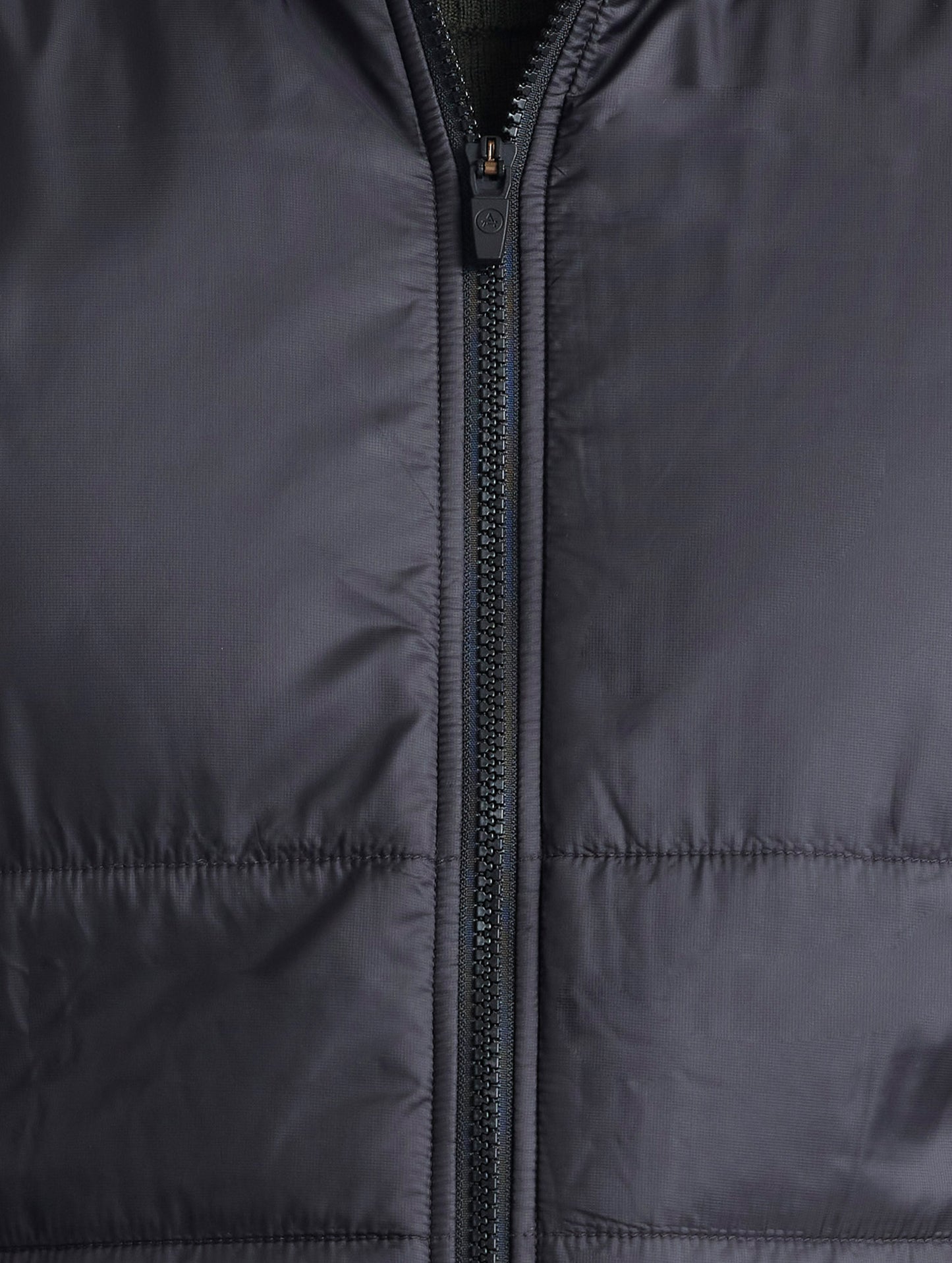 Closeup view of center zipper of Eco Insulated Vest in Onyx Black from AETHER Apparel.