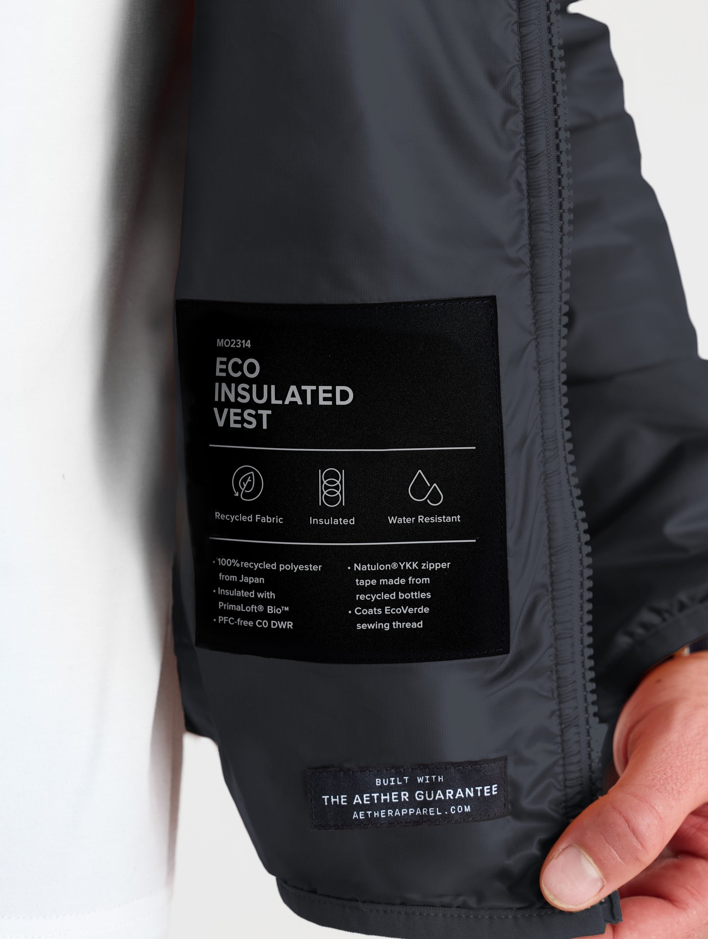 Closeup view of wearer's left interior label of Eco Insulated Vest in Onyx Black from AETHER Apparel.