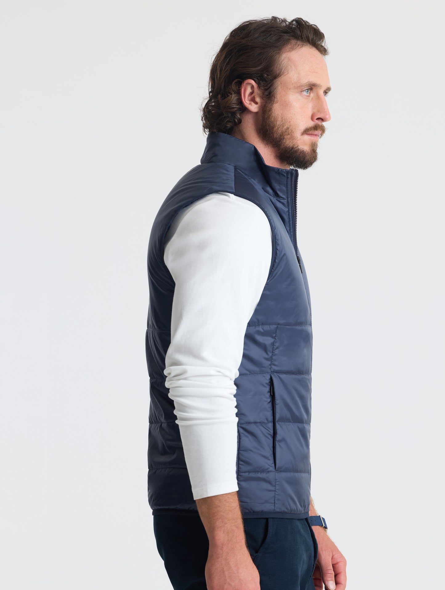 Right profile view of man wearing Eco Insulated Vest in Total Eclipse dark blue from AETHER Apparel.