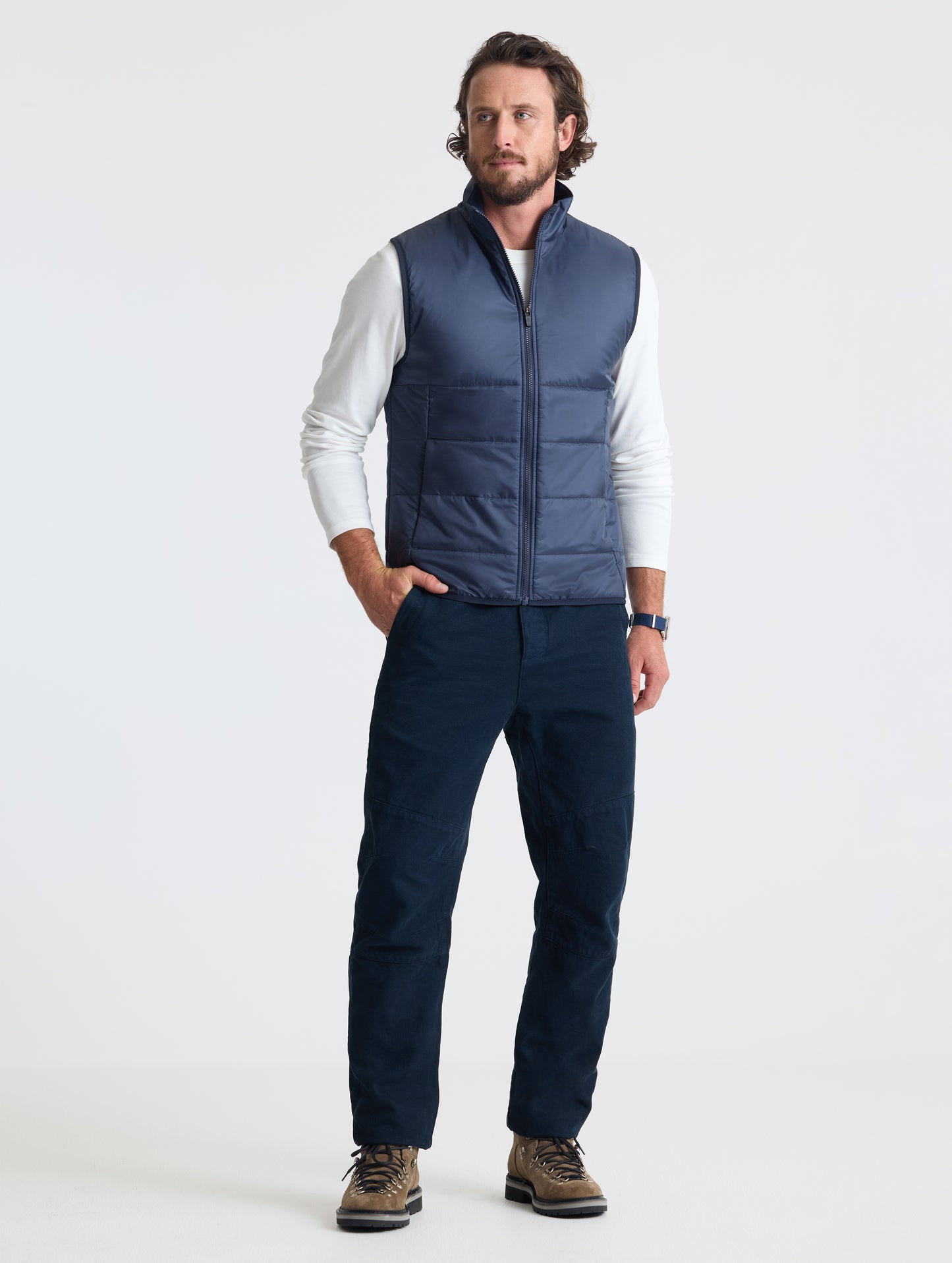 Full body view of man wearing Eco Insulated Vest in Total Eclipse dark blue from AETHER Apparel.