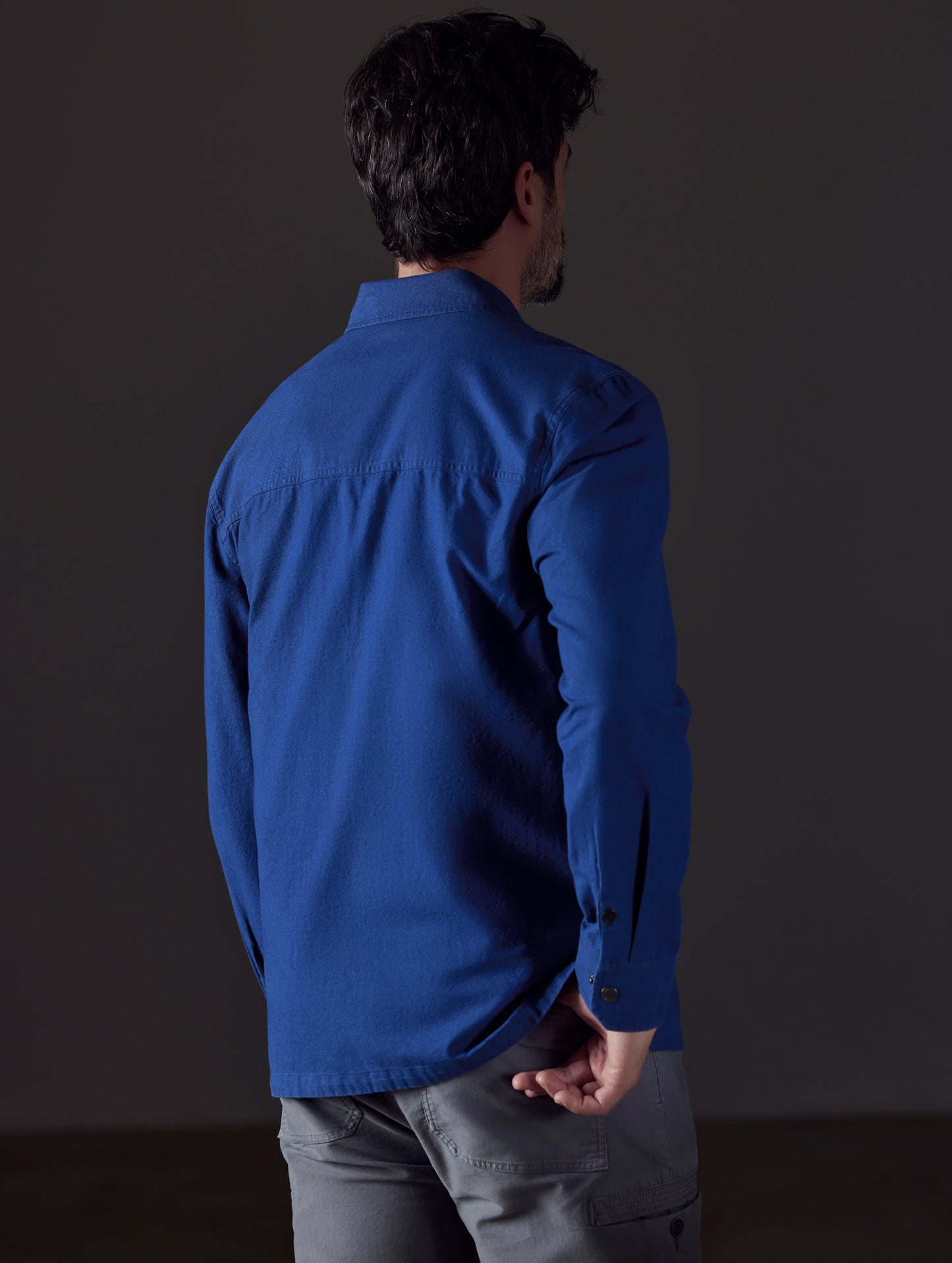 Rear 3/4 body view of man wearing Emerson Button Down in Dark Blue from AETHER Apparel.