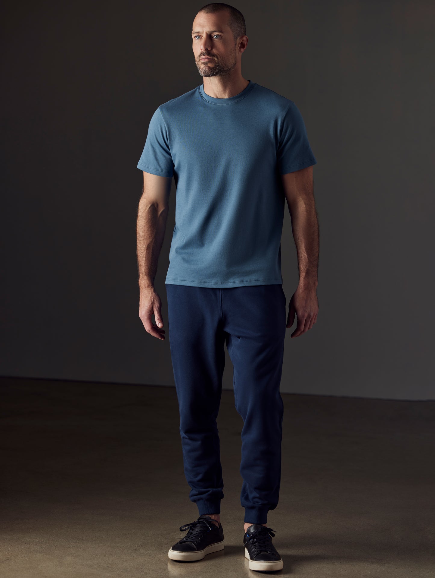 Front full-body view of man wearing Emery Pima Crew Tee in Coastal Blue from AETHER Apparel.