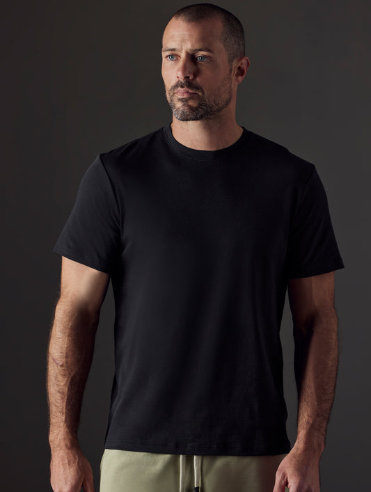 Front body view of man wearing Emery Pima Crew Tee in Onyx Black from AETHER Apparel.