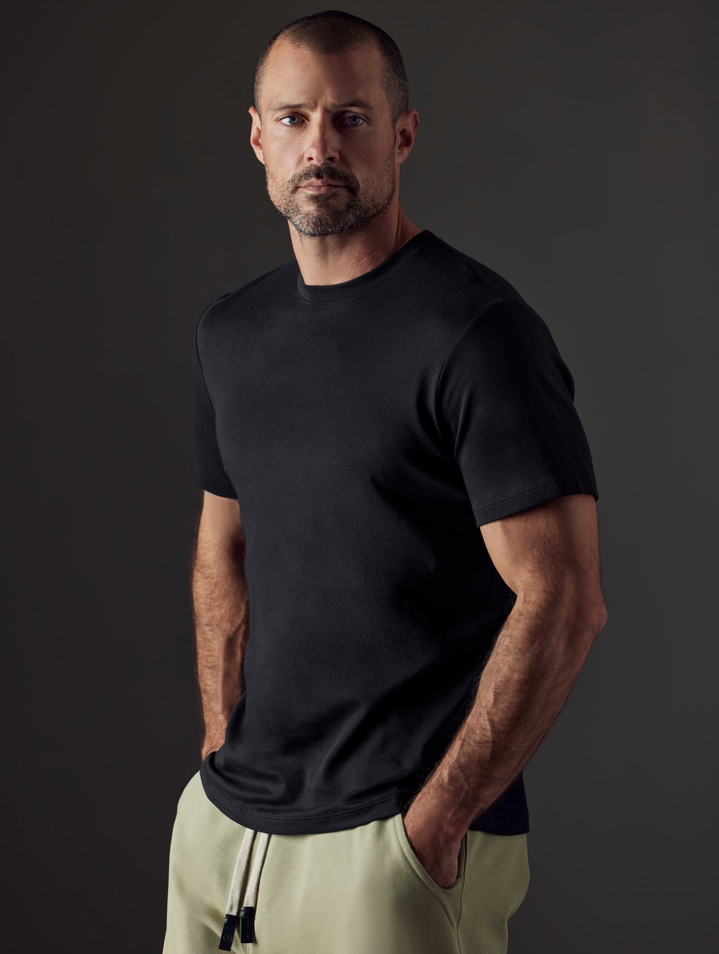 Front 3/4 body view of man wearing Emery Pima Crew Tee in Onyx Black from AETHER Apparel.