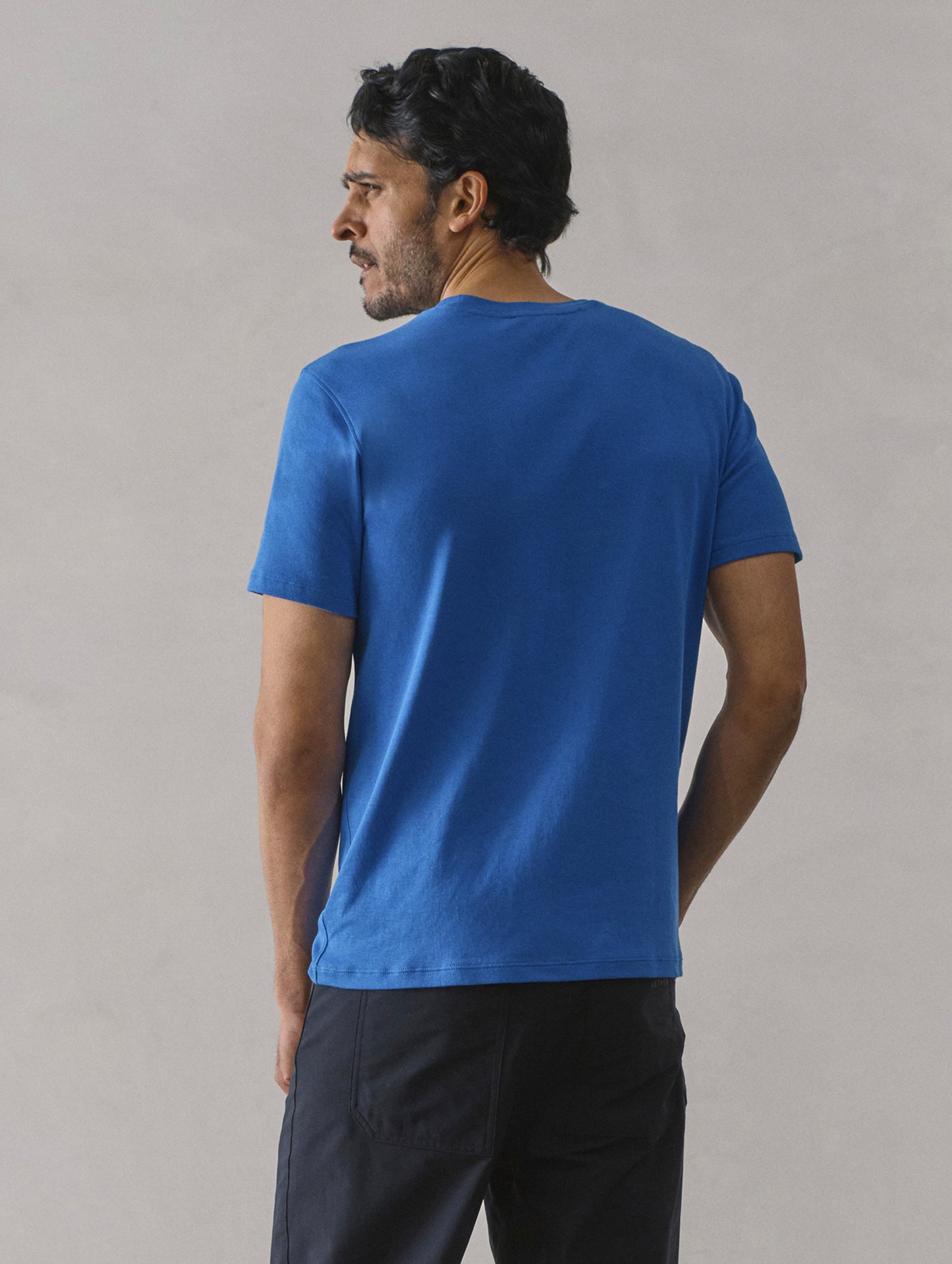 Rear view of man wearing Emery Pima Crew Tee in Summit Blue from AETHER Apparel.
